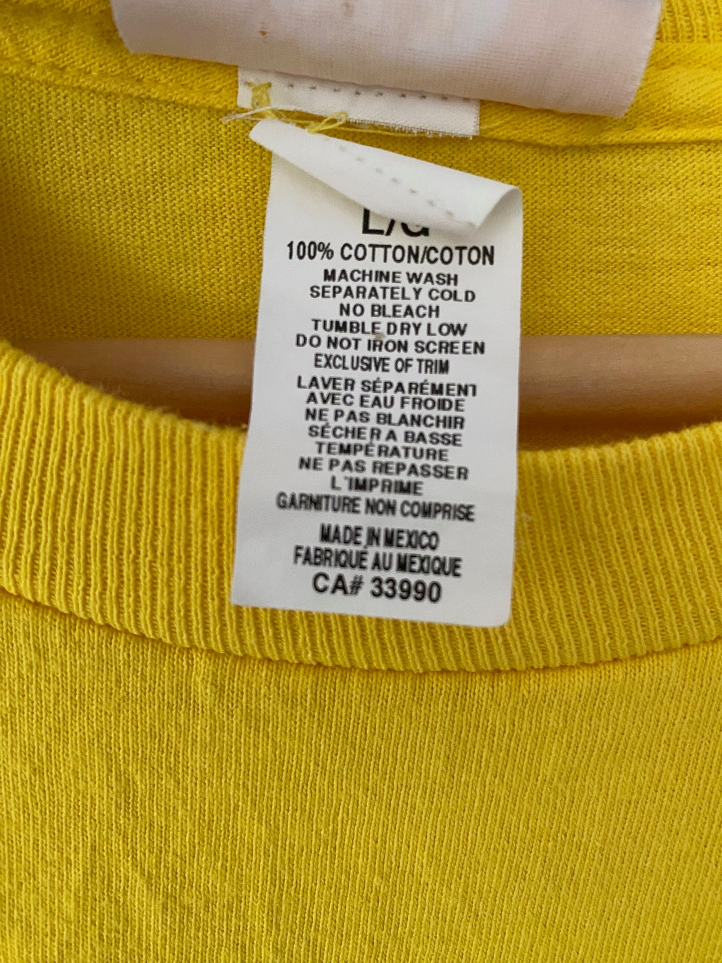 tag with car instruction size large on a yellow t-shirt