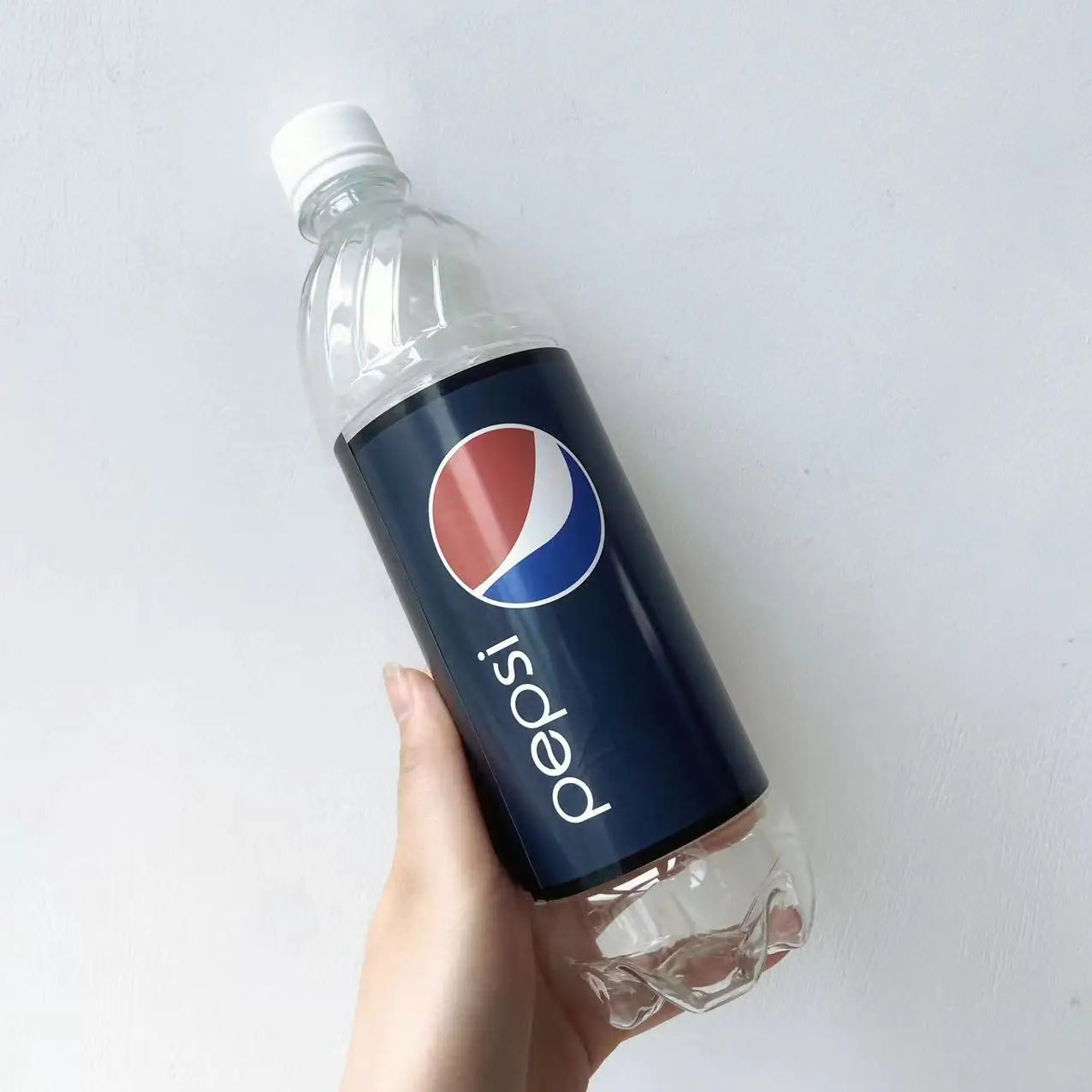 empty clear pepsi bottle with white cap