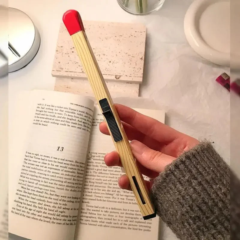 hand holding a giant match in front of a book