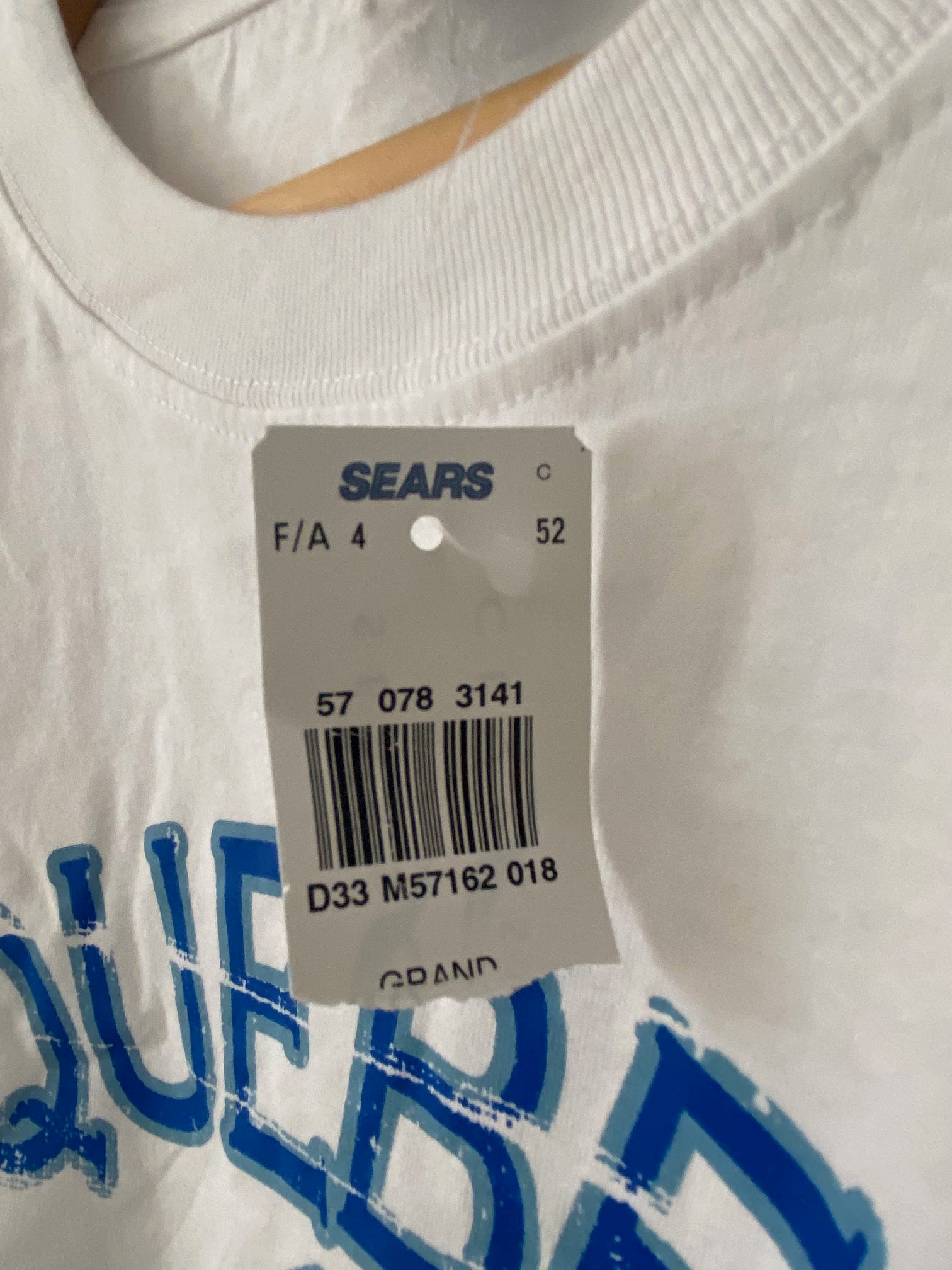 sears tag hanging on a white quebec t-shirt