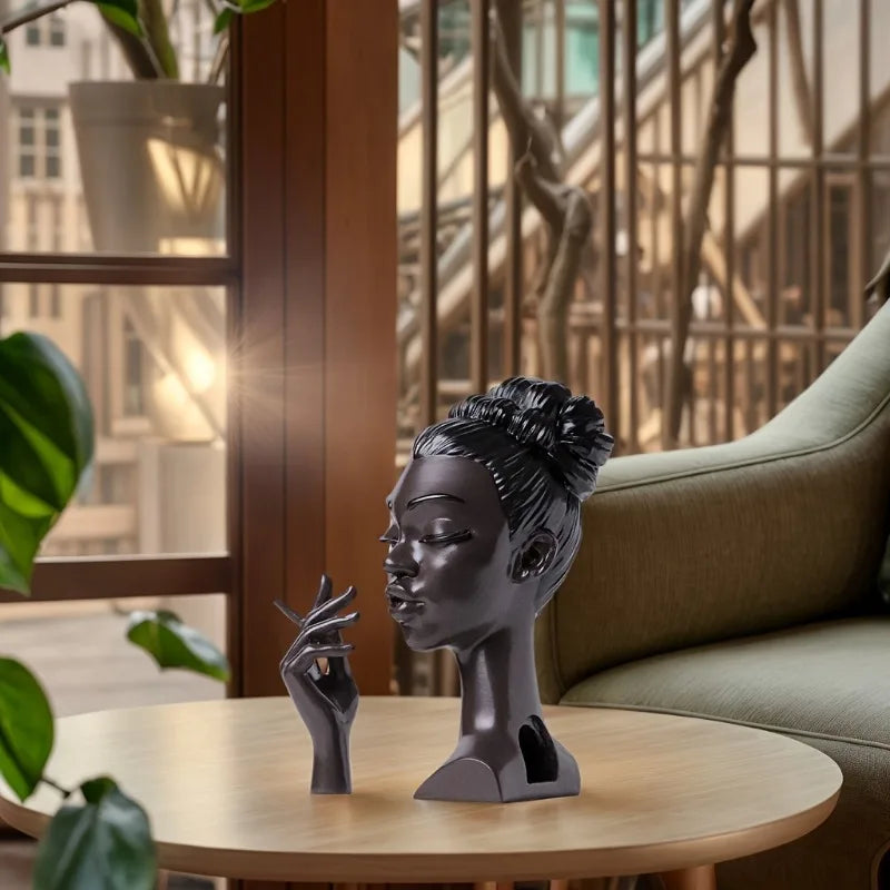 black plastic women holding a cigarette incense holder on a table inside a appartmen